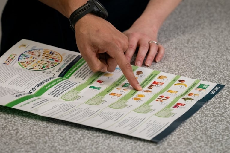 Serving size food and drink factsheet being viewed on table for healthy weight goals