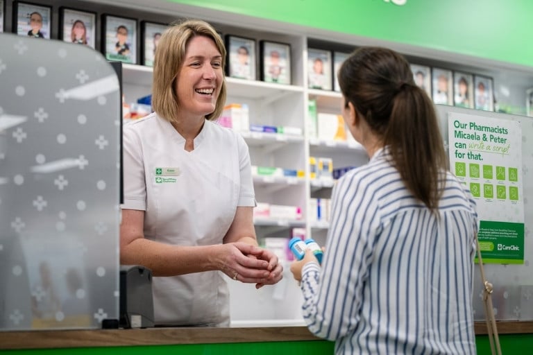 Female pharmacist discussing supplements with a female customer at the store counter