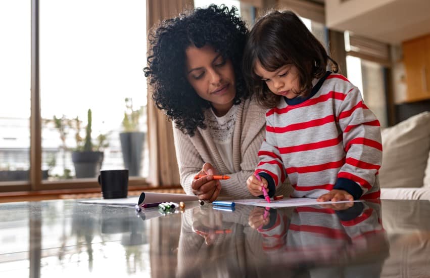 Mother and child colouring in at coffee table