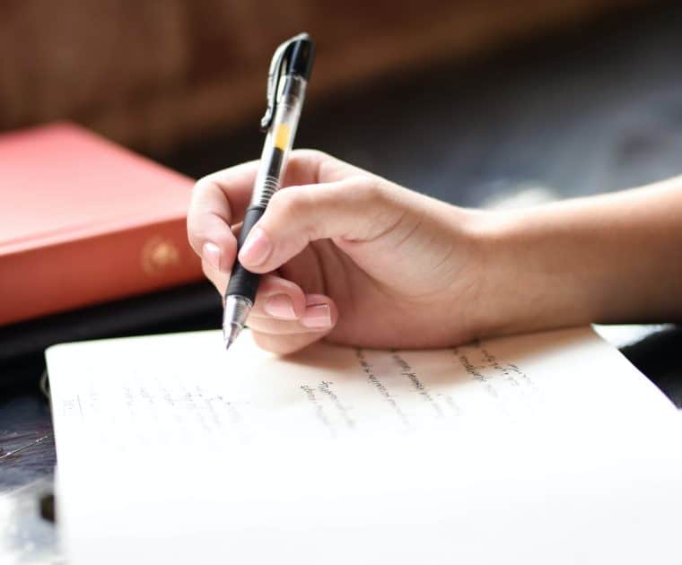 Close up of a person writing in a journal