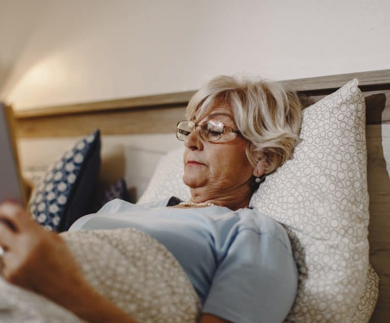 Mature women reading in bed