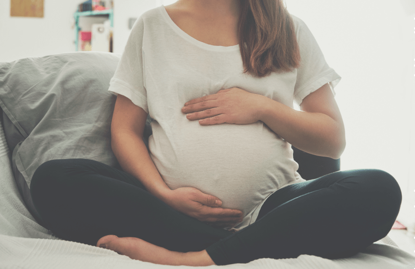 Pregnant woman holds belly