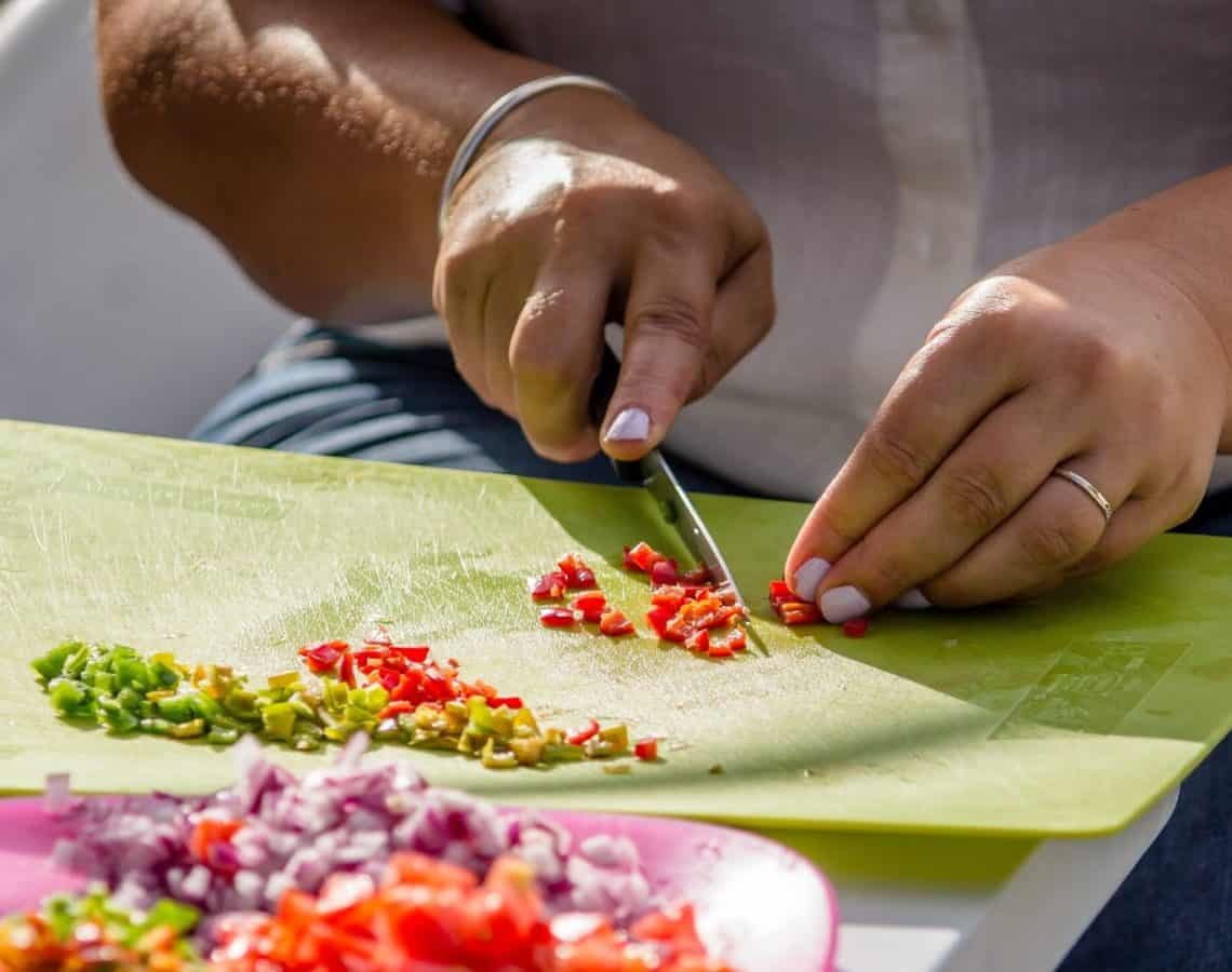 Close up of a woman finely dicing chillies