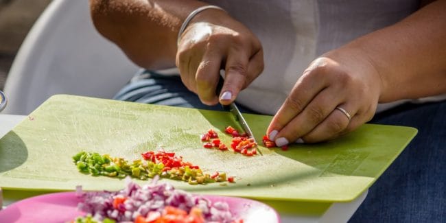 Close up of a woman finely dicing chillies