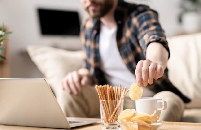 Man snacking in front of laptop