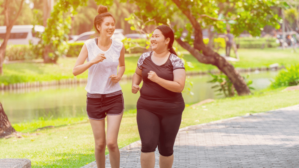Two young women running along a path in a park