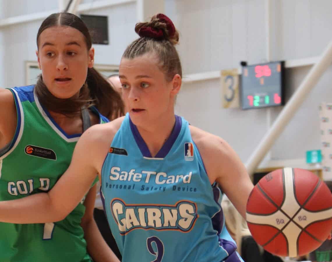 2 young females playing basketball on in indoor basketball court