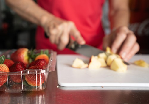 Cutting apples and strawberries.