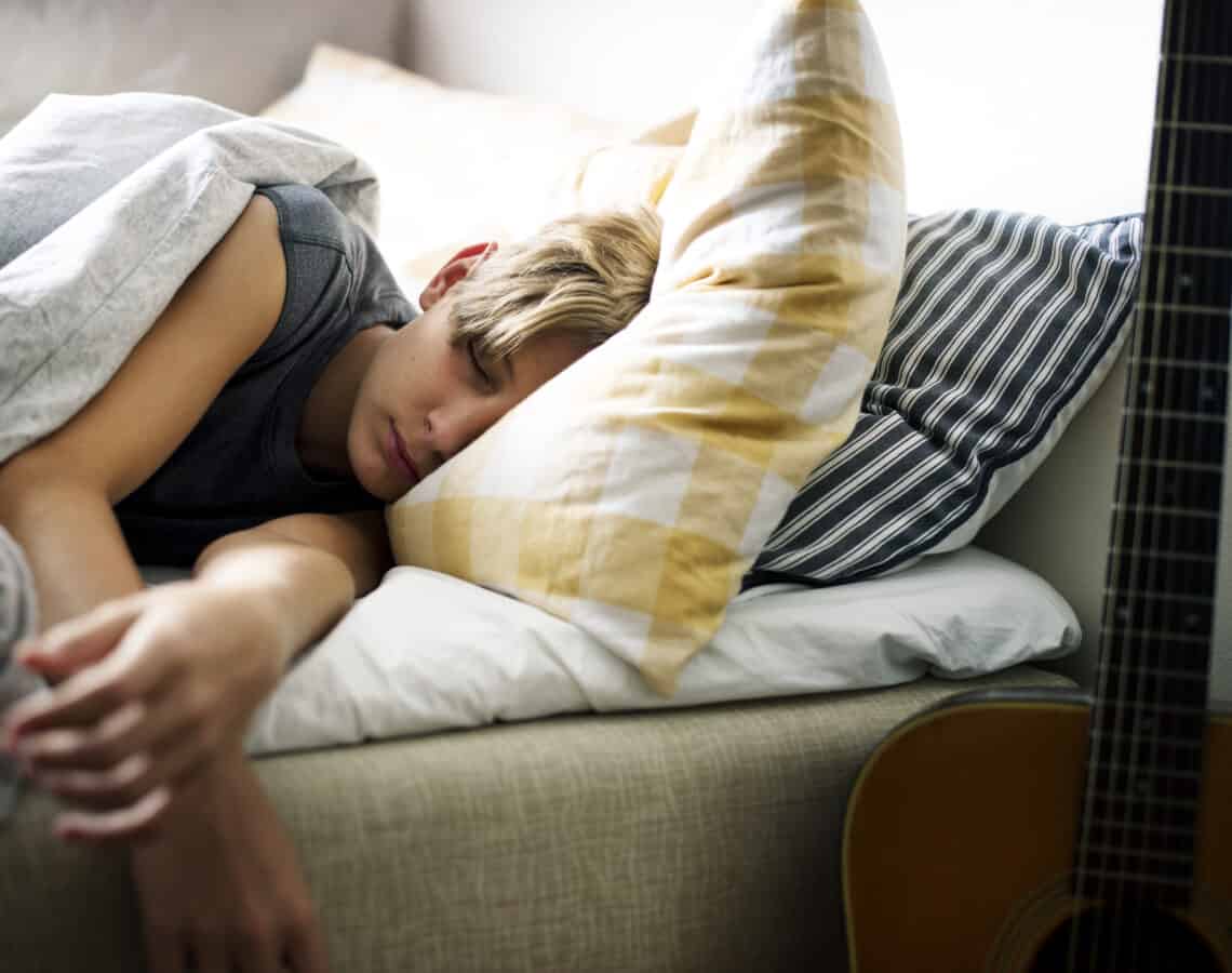 Young caucasian boy sleeping in bed