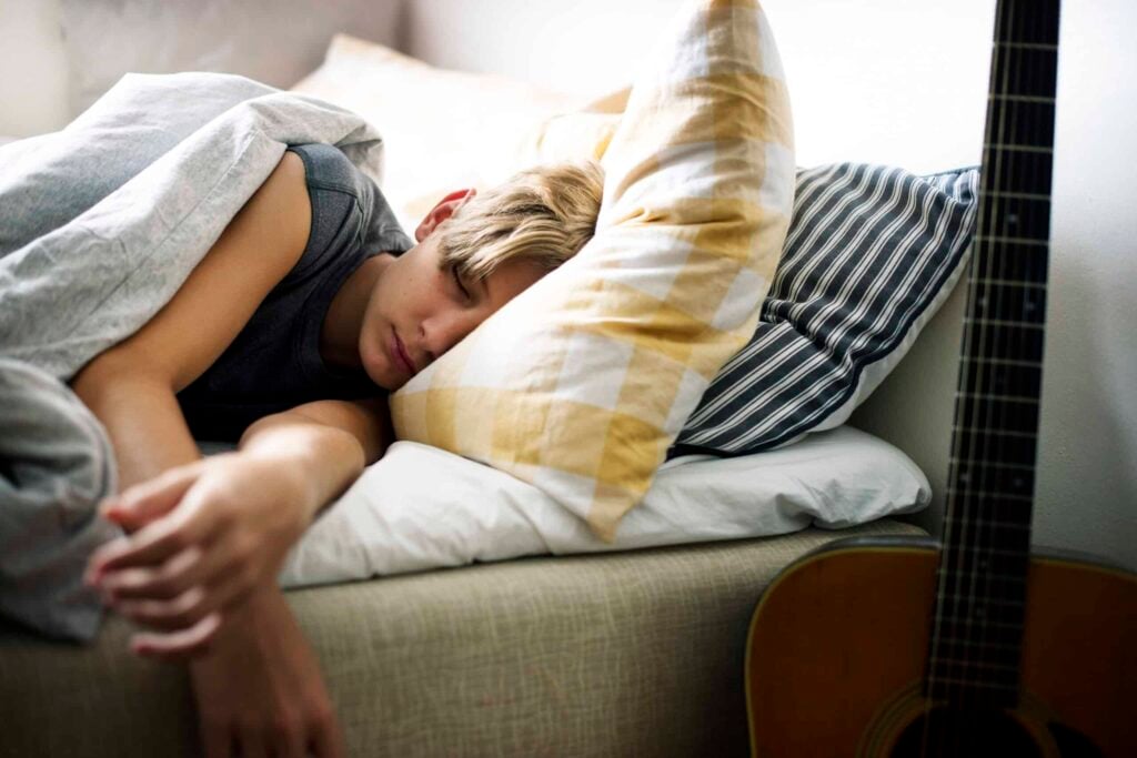 Young caucasian boy sleeping in bed