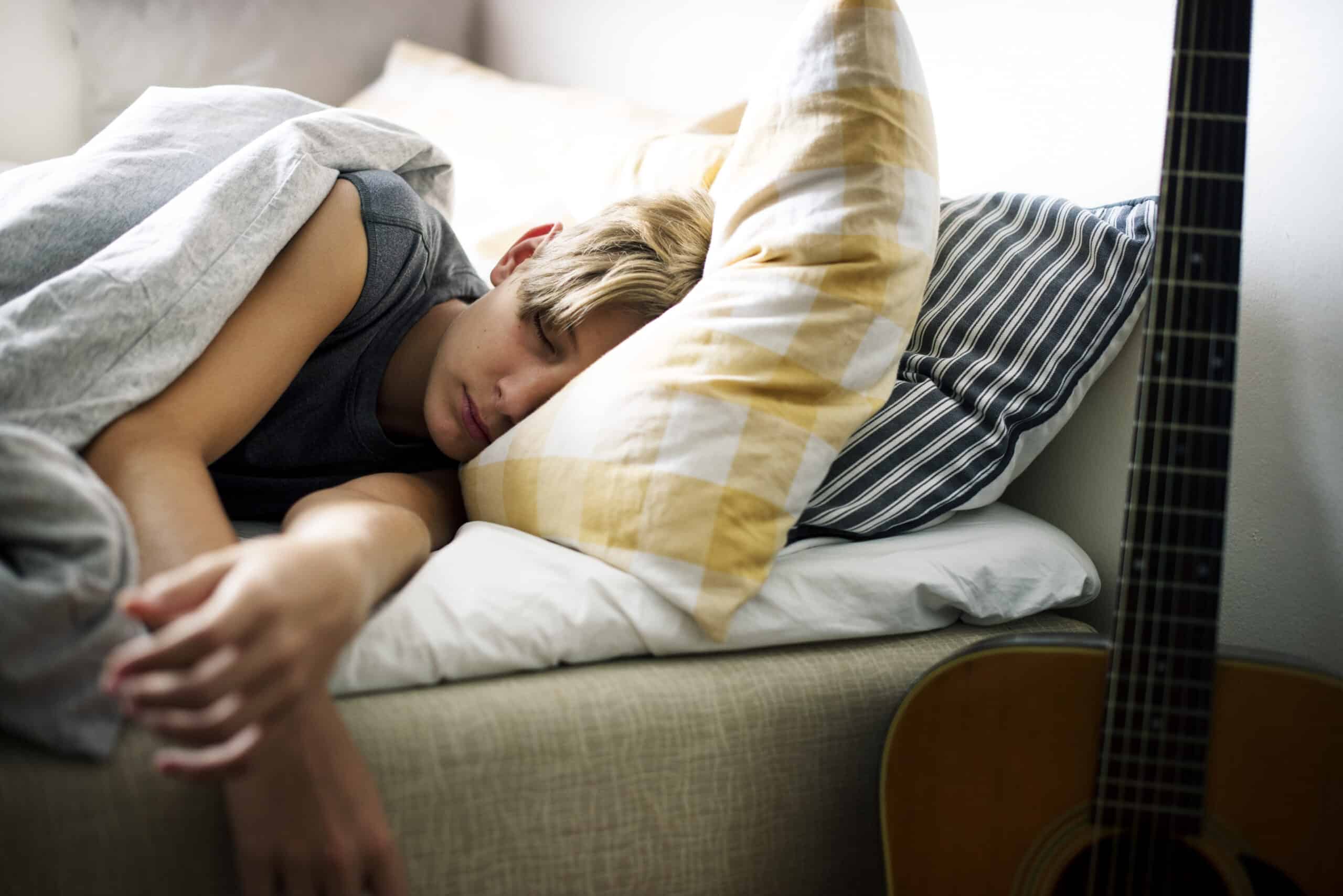 Young caucasian boy sleeping in bed