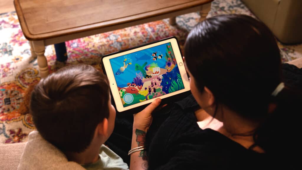 Mother and son look at Poadsquad on the iPad