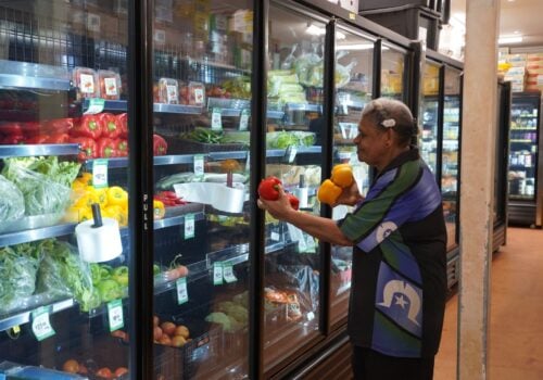 A person stocking fresh produce in a regional store