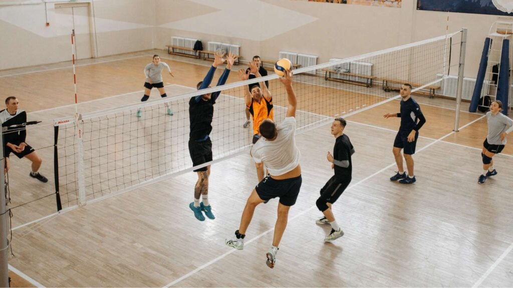 Group of adults playing indoor volleyball