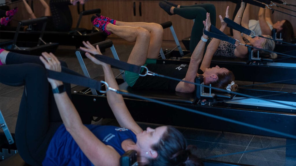 A group of women in a reformer Pilates studio