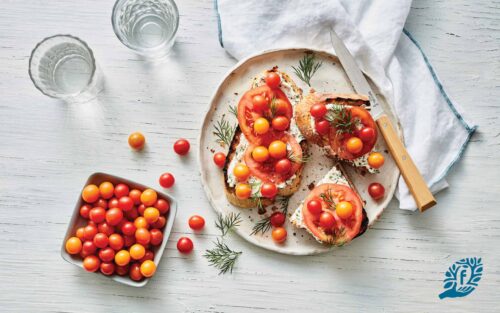 Cherry tomatoes and goat cheese on toasted crusty bread slices