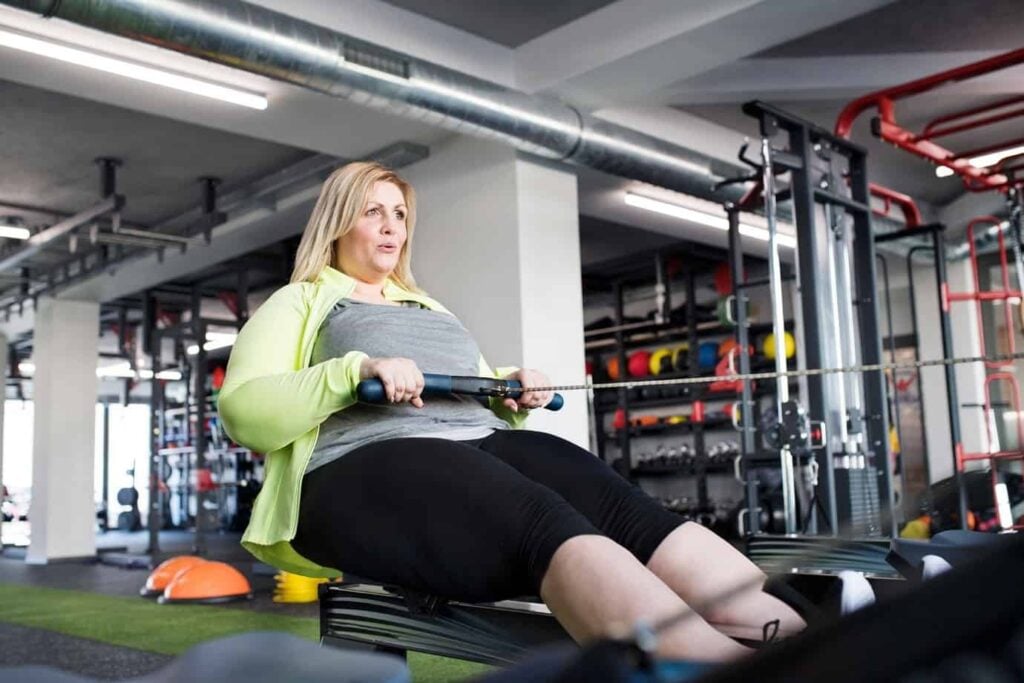 Woman uses rowing machine at the gym