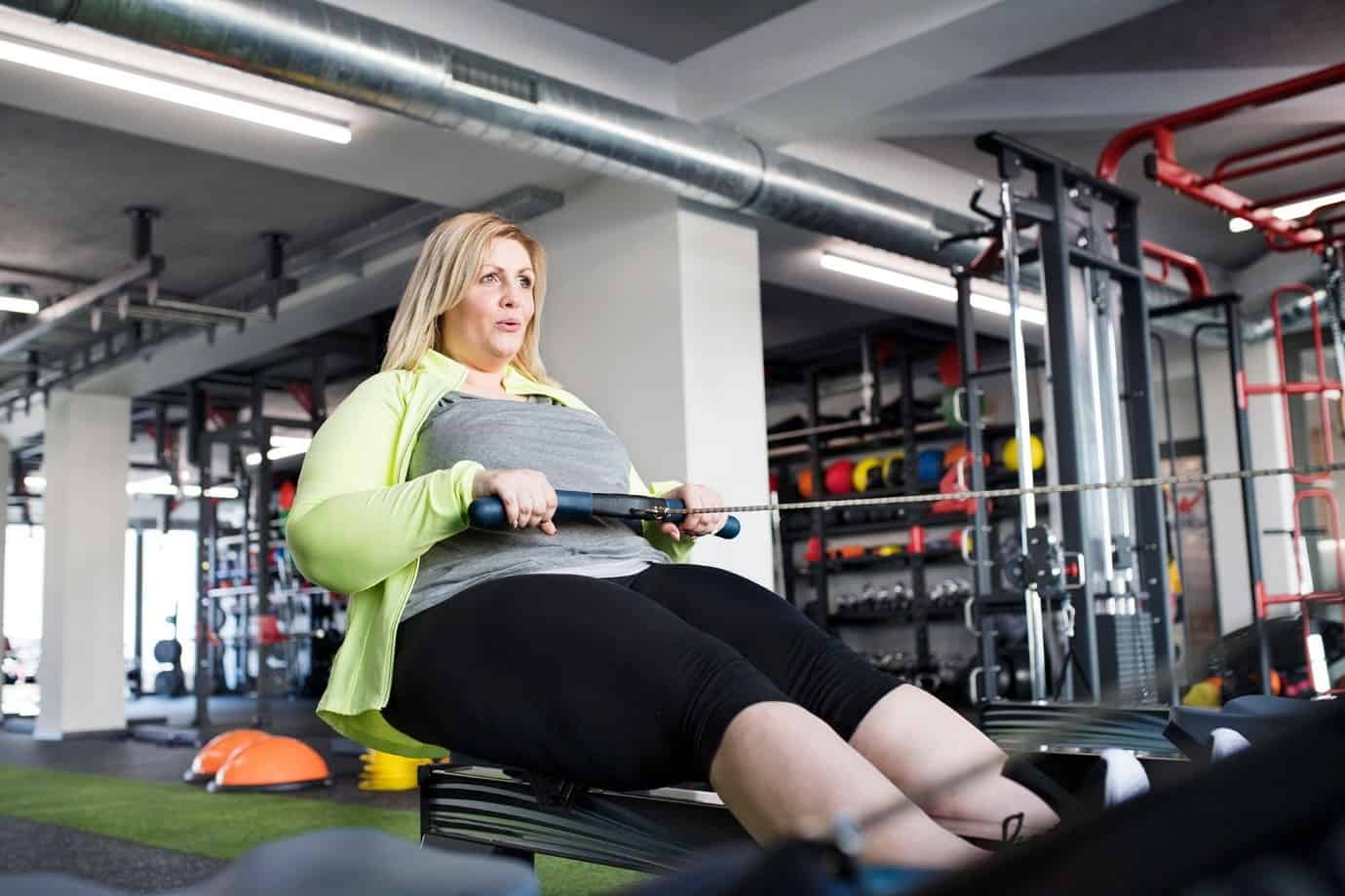 Woman uses rowing machine at the gym