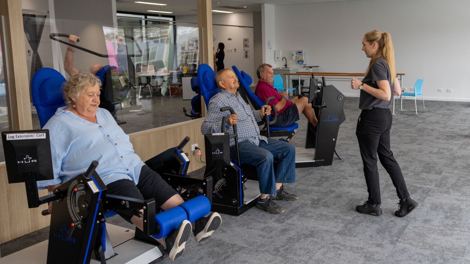 A group of people exercising on gym equipment.