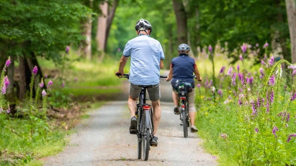 older couple bike ride together on pathway