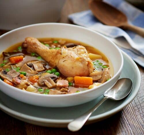 Chicken drumstick sits on top of a bed of vegetable casserole