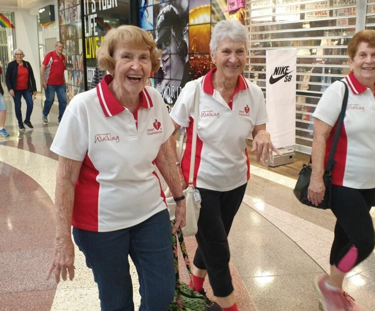 A group of seniors participate in an indoor walking group at a local shopping centre