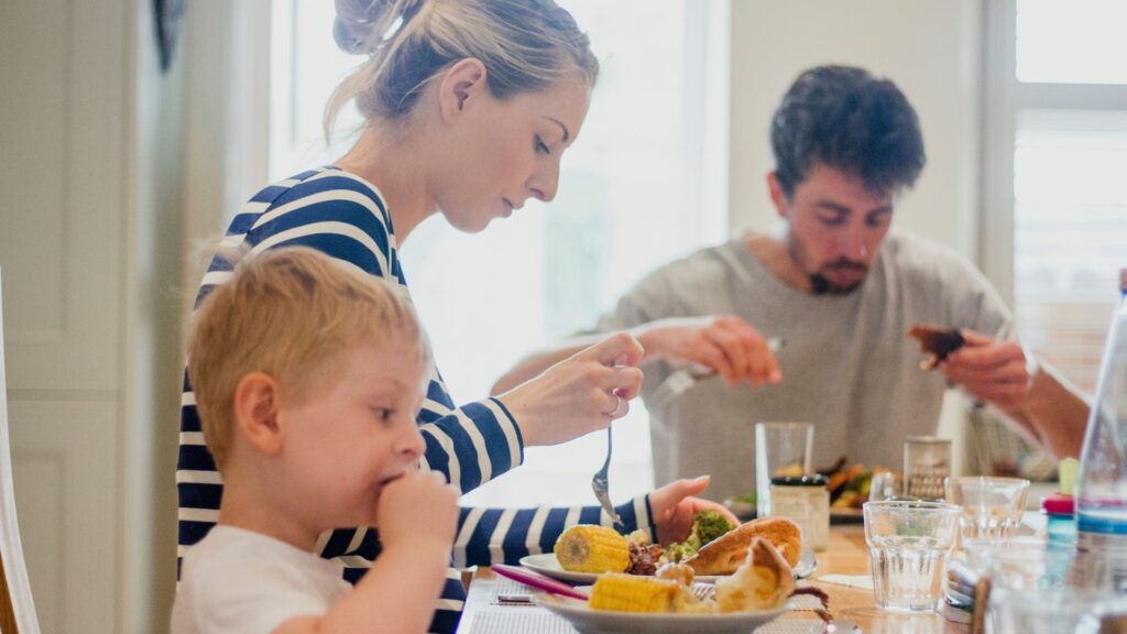 Family eating dinner at the dining table together, with mum, dad and young boy