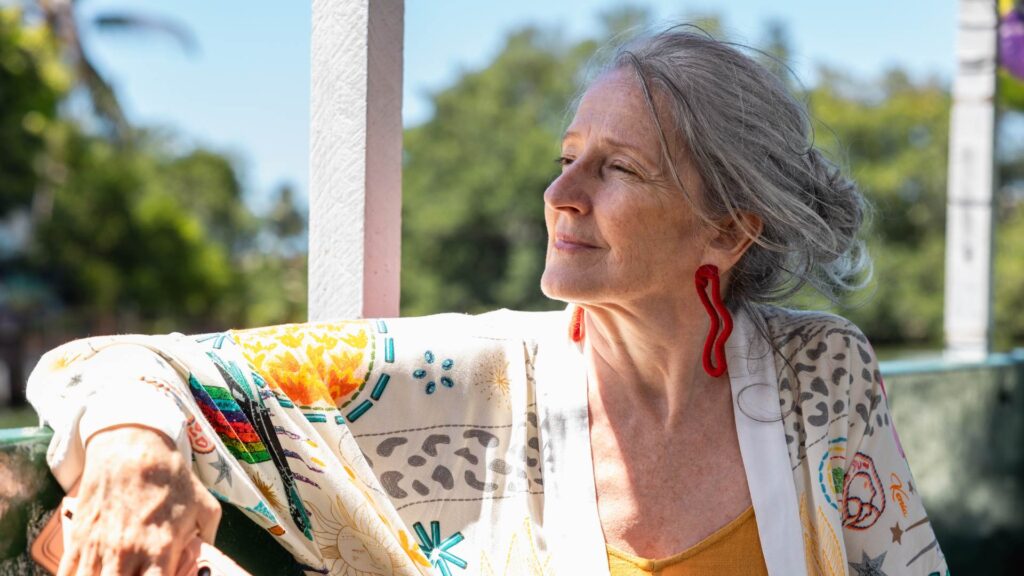Older woman sits on her patio staring into the distance