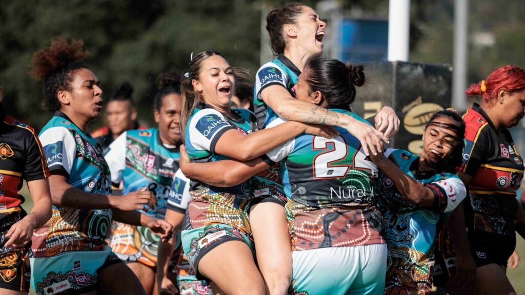 Women from a First Nations rugby league team celebrate after a try