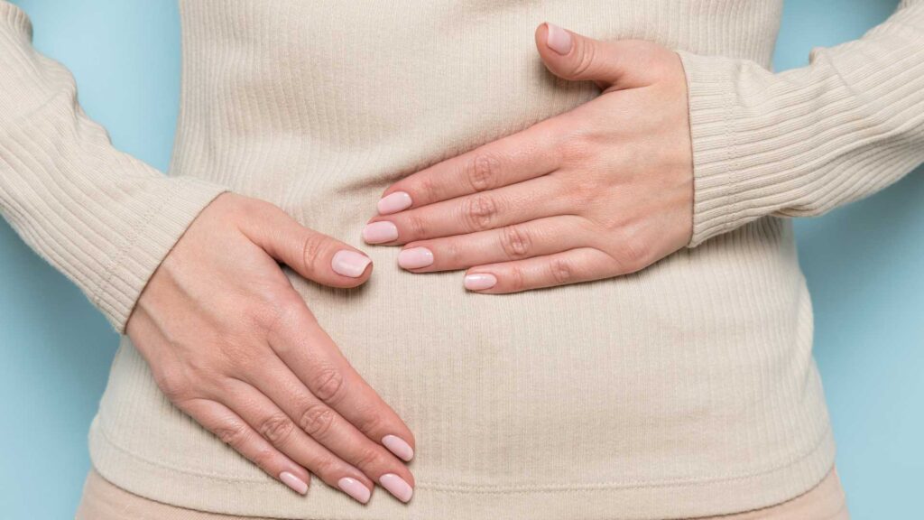 Woman places hands over her stomach