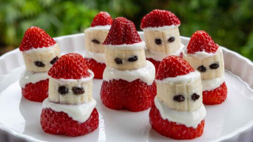 Strawberry santas on a plate, with greek yoghurt and currants