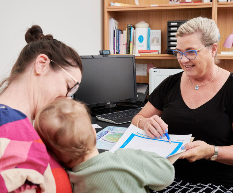 Clinician pointing at growth chart with patient and child