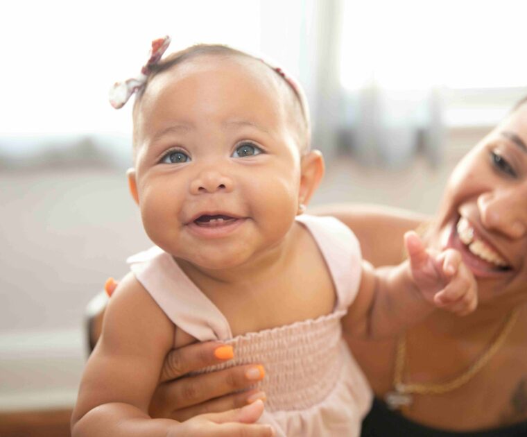 Woman holding smiling baby girl