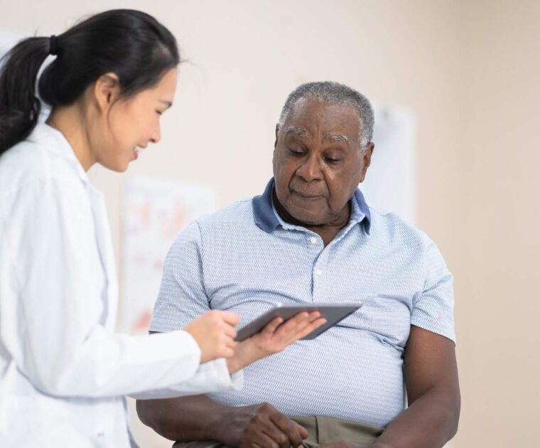 Doctor showing man information on tablet