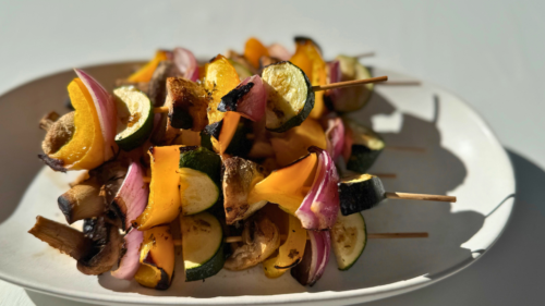 Mushroom, Red Onion, Yellow Capsicum and Zucchini grilled on a skewer.