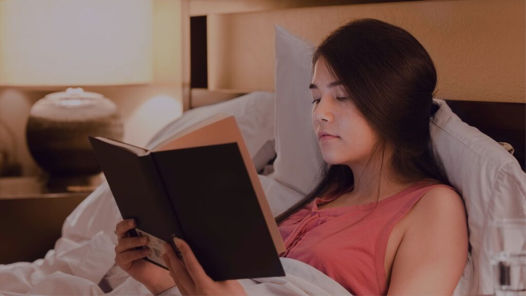 A women reading a book in bed
