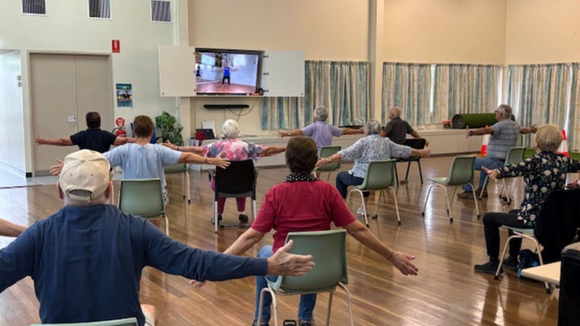 A group of people doing a chair yoga class