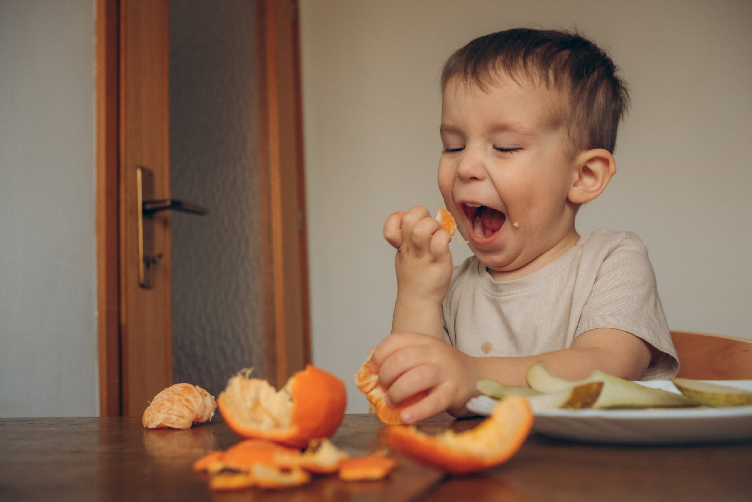 A toddler eating a mandarin
