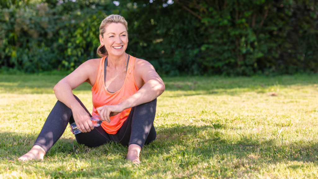A person sitting on the grass with a bottle of water