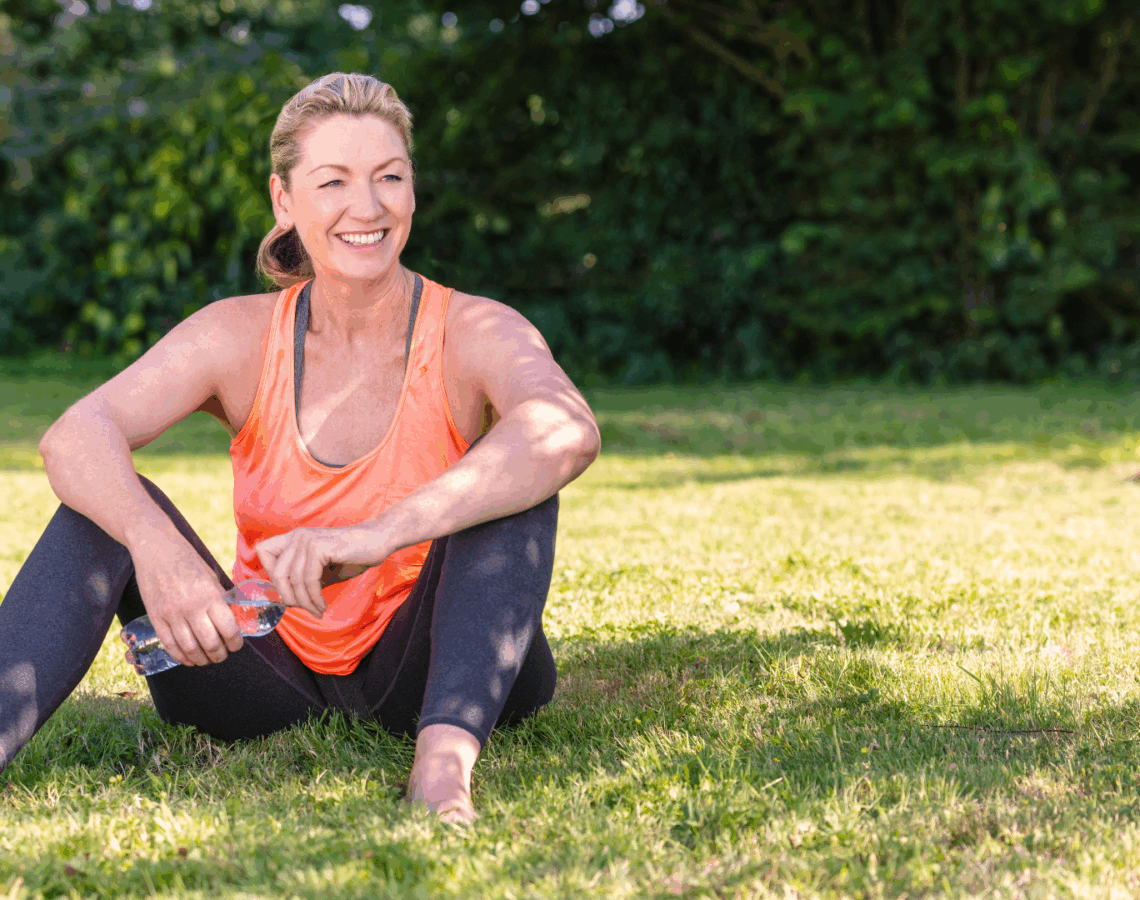 A person sitting on the grass with a bottle of water