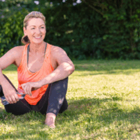 A person sitting on the grass with a bottle of water