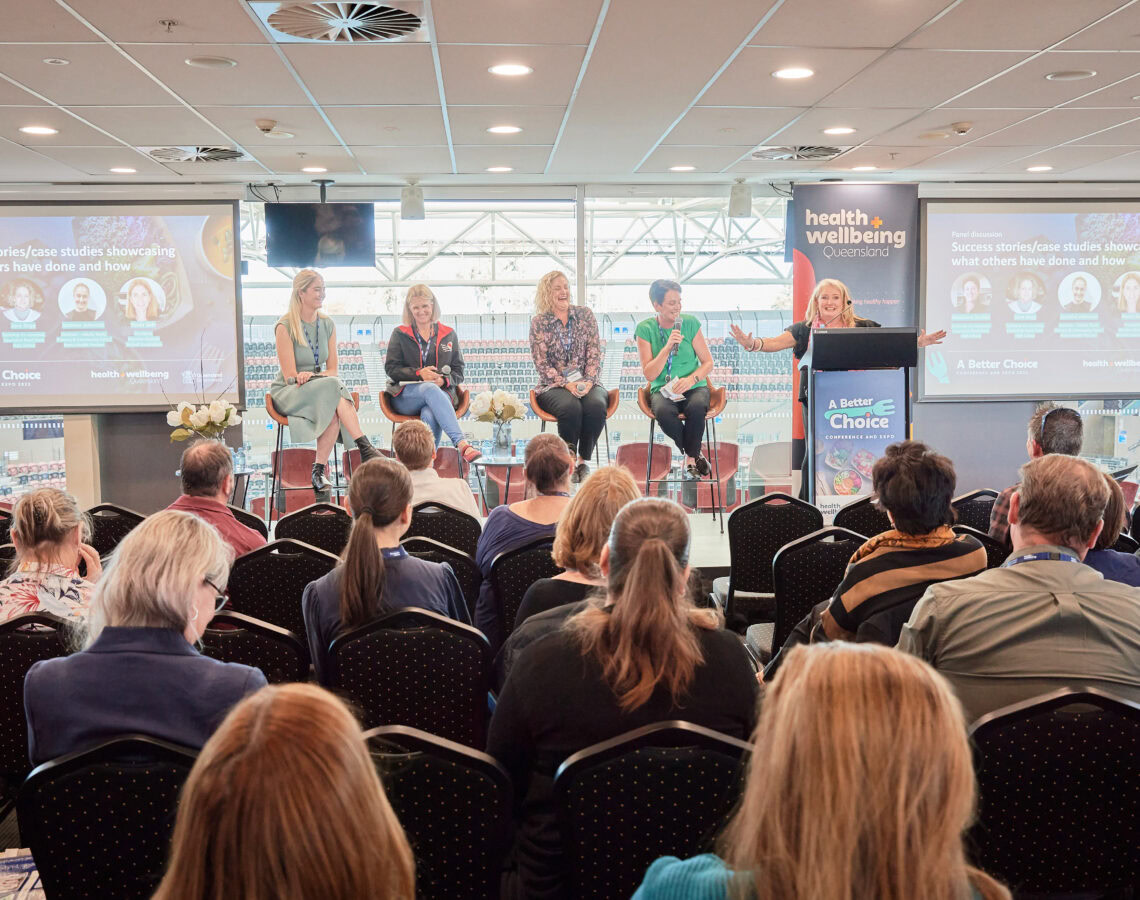 A group of people watching a panel talk on stage at the ABC conference 2023