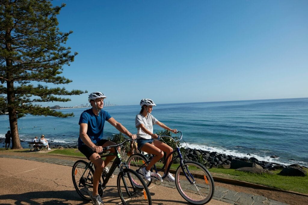 Two individuals bike riding at Burleigh Heads, Queensland