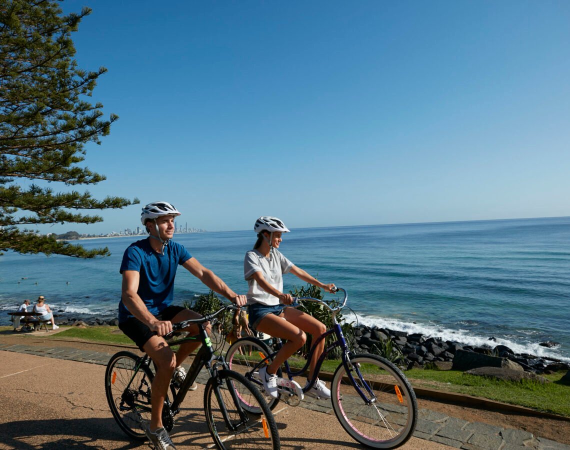 Two individuals bike riding at Burleigh Heads, Queensland