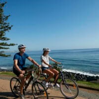 Two individuals bike riding at Burleigh Heads, Queensland