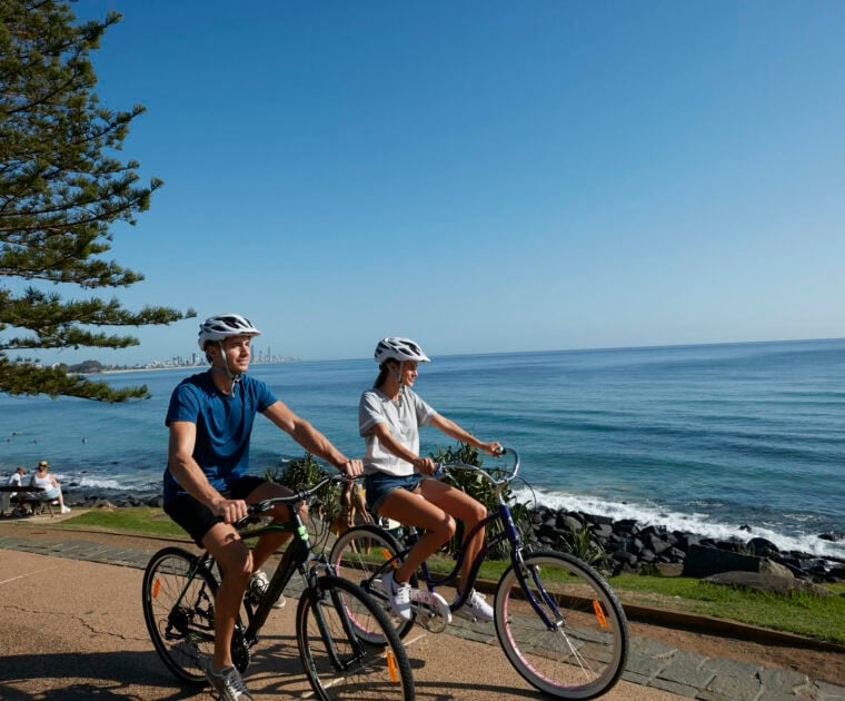 Two individuals bike riding at Burleigh Heads, Queensland