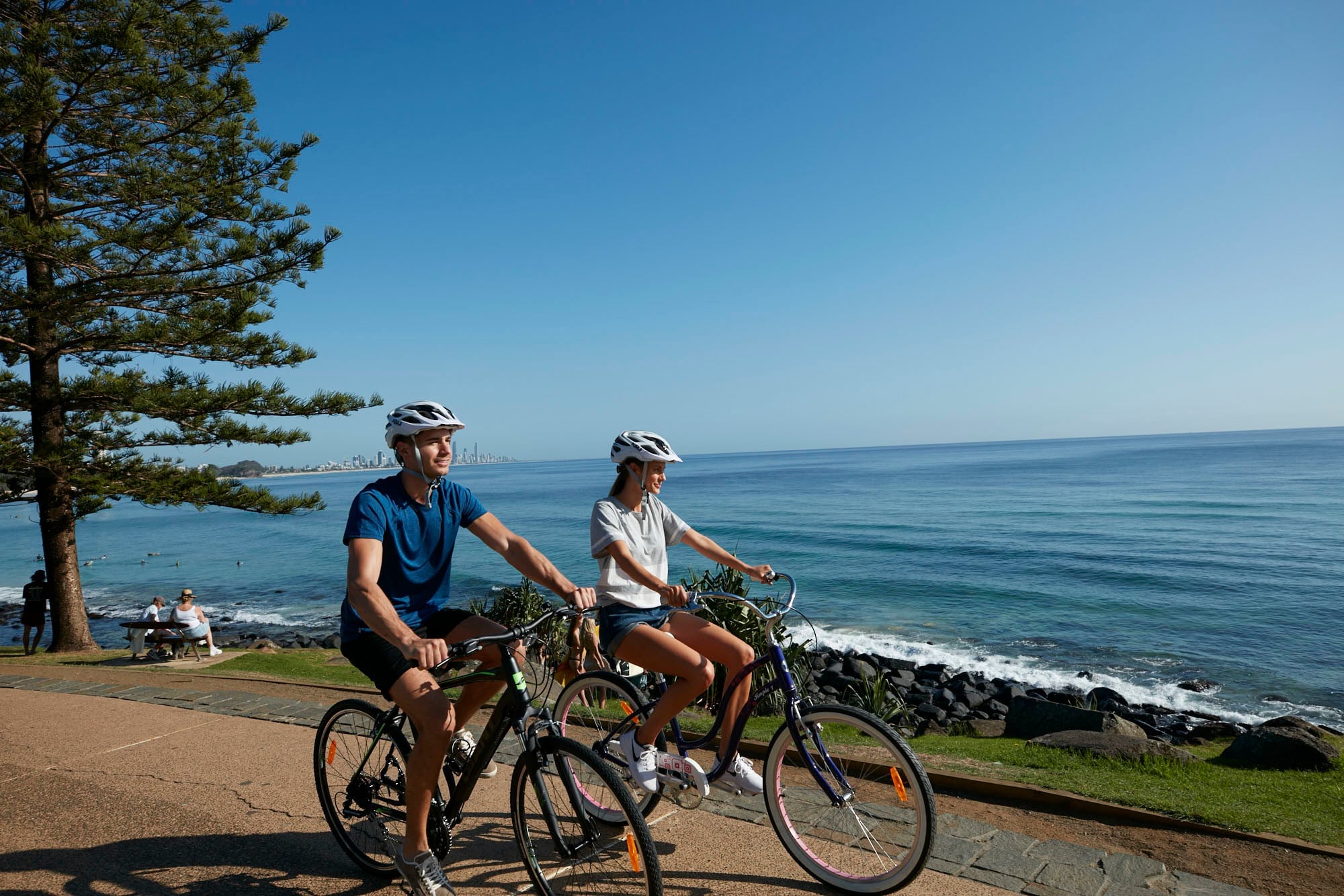 Two individuals bike riding at Burleigh Heads, Queensland