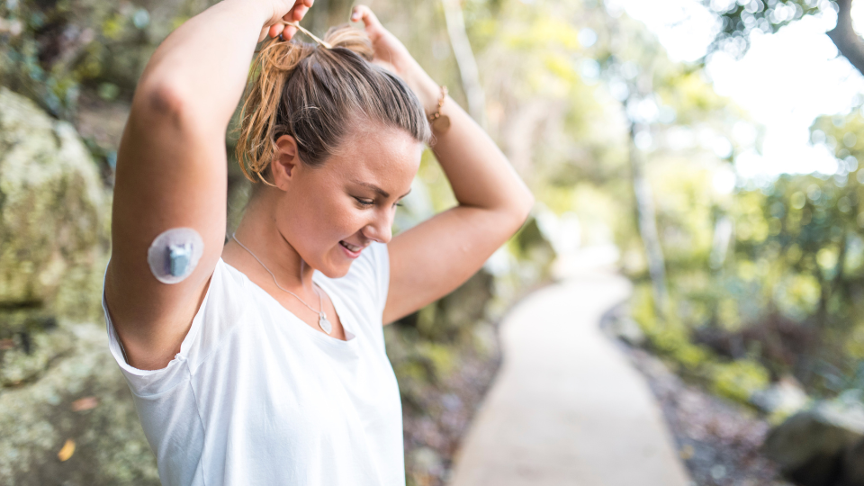 Woman on walk with medical device on her arm.