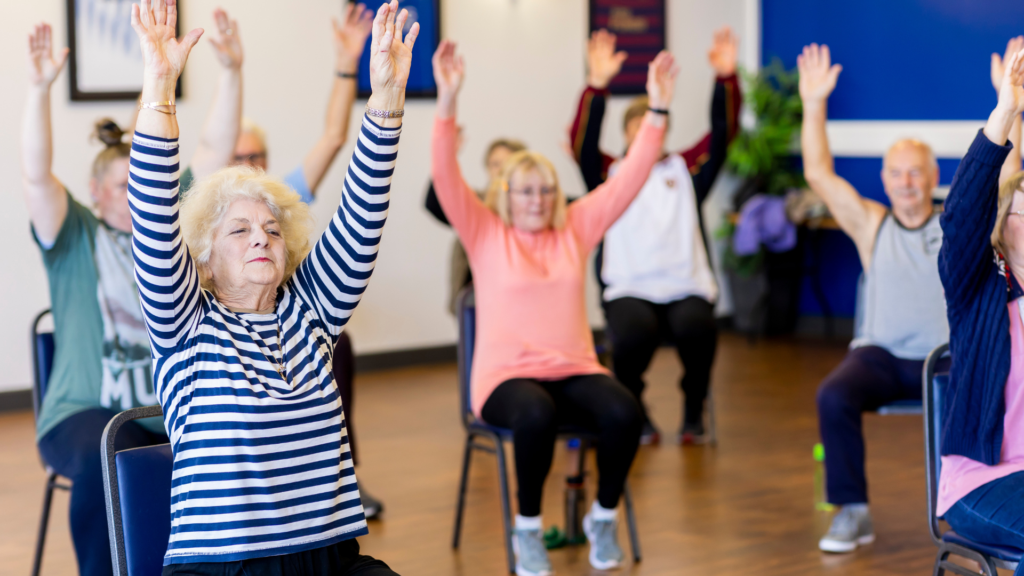 People sitting in chairs during an exercise class.