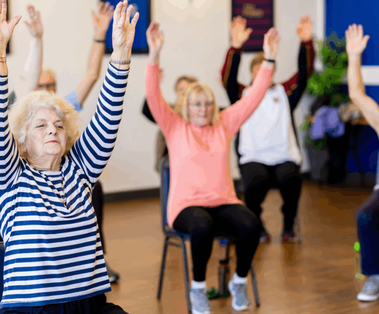 People sitting in chairs during an exercise class.